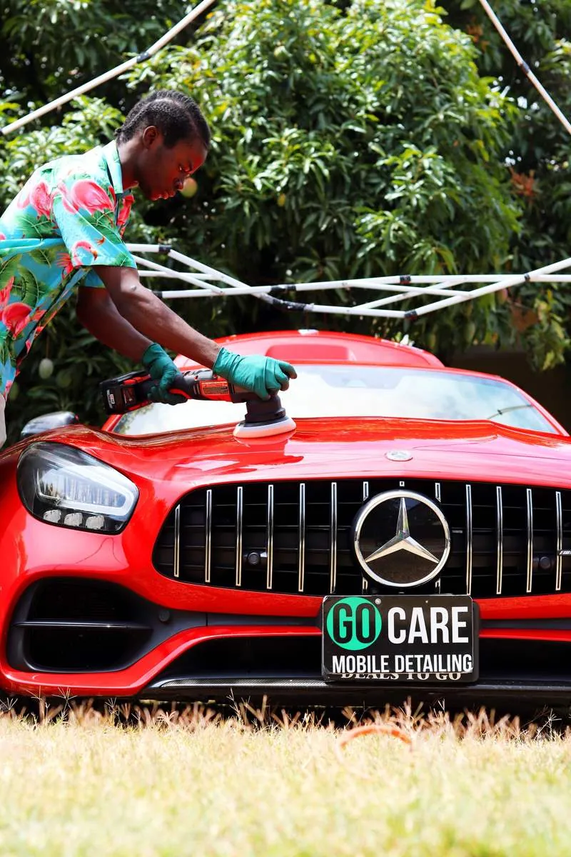 Technician polishing a red Mercedes